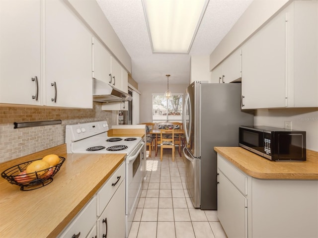 kitchen with light tile patterned flooring, appliances with stainless steel finishes, white cabinets, and decorative light fixtures