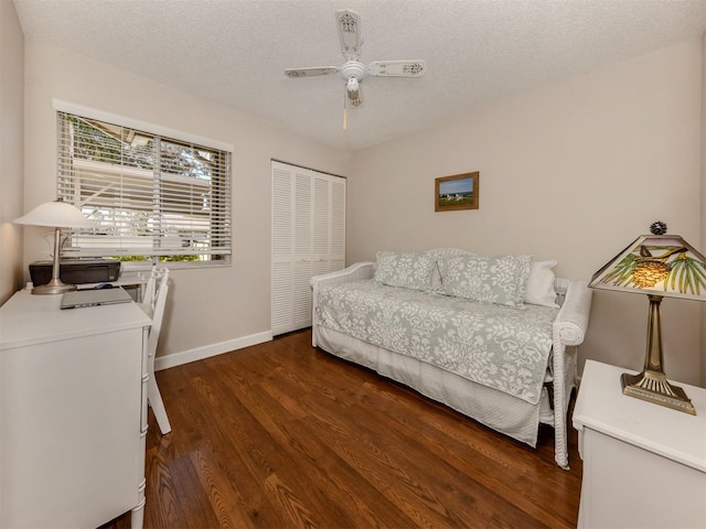 bedroom featuring ceiling fan, dark wood-type flooring, a closet, and a textured ceiling