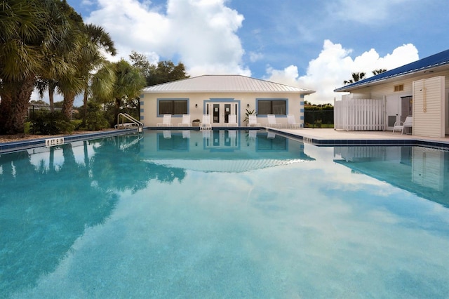 view of swimming pool with french doors and a patio