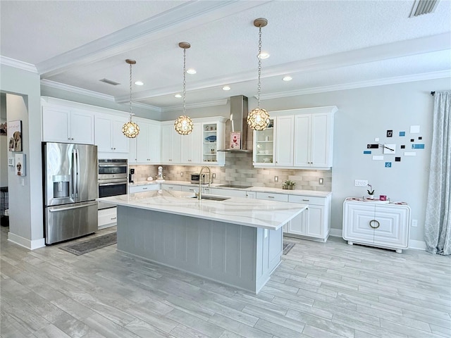 kitchen featuring white cabinetry, stainless steel appliances, an island with sink, and wall chimney range hood