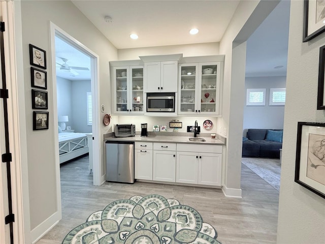 bar featuring stainless steel microwave, refrigerator, light hardwood / wood-style floors, and white cabinets