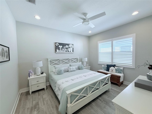 bedroom with wood-type flooring, ceiling fan, and a textured ceiling