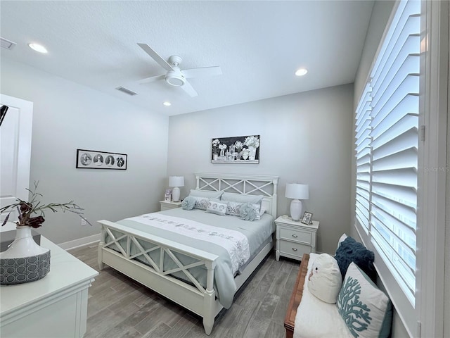 bedroom featuring ceiling fan, a textured ceiling, and dark hardwood / wood-style flooring