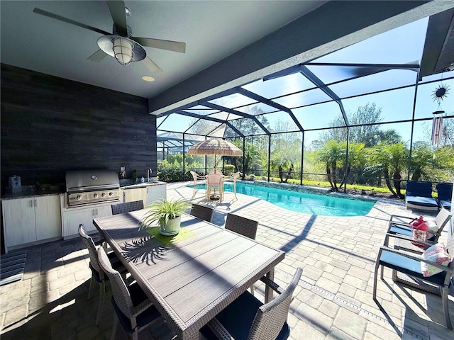 view of pool featuring sink, ceiling fan, a patio area, area for grilling, and exterior kitchen