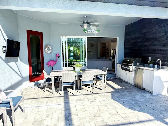 view of patio / terrace featuring ceiling fan, area for grilling, a grill, and sink