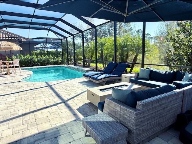 view of swimming pool with a lanai, a patio area, and an outdoor living space with a fire pit