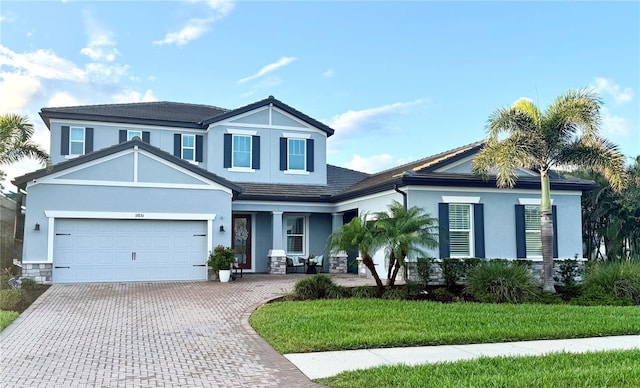 traditional home with stucco siding, decorative driveway, and a garage