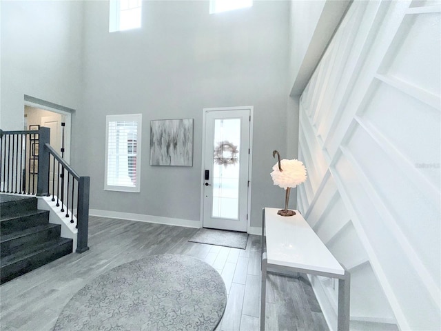 foyer featuring a healthy amount of sunlight, wood finished floors, and stairs