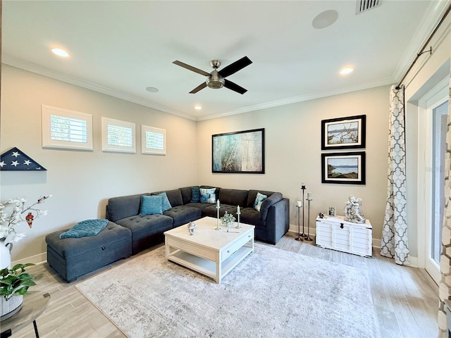 living room with crown molding, a ceiling fan, light wood-style floors, and baseboards