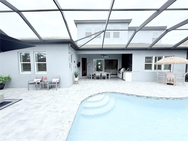 rear view of property with a lanai, a patio area, and stucco siding