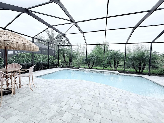 pool featuring glass enclosure and a patio