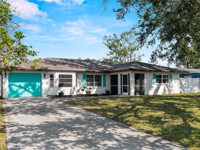 ranch-style house with a garage, a sunroom, and a front lawn