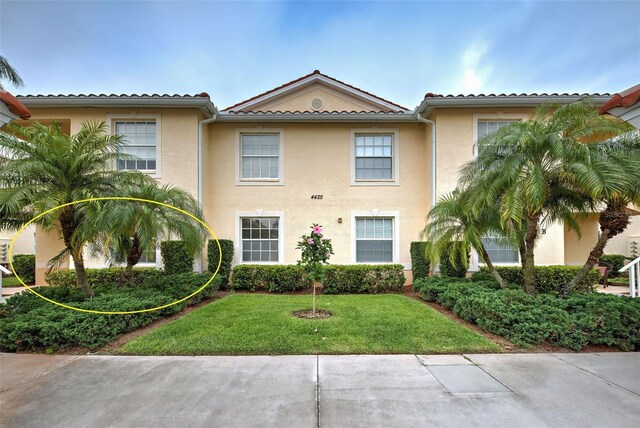 mediterranean / spanish-style home with a front yard