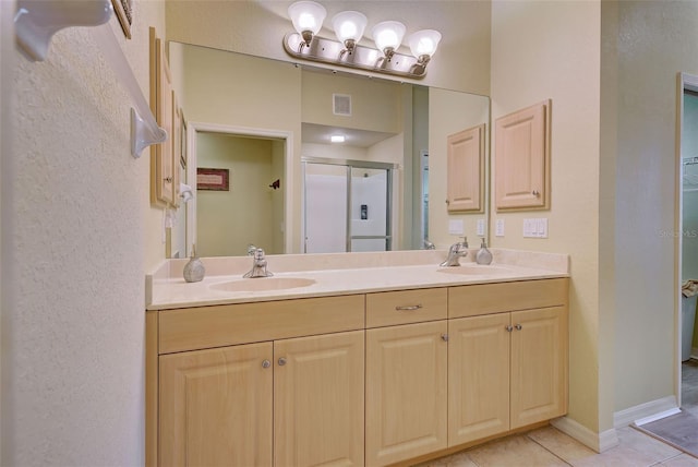 bathroom with walk in shower, vanity, and tile patterned flooring