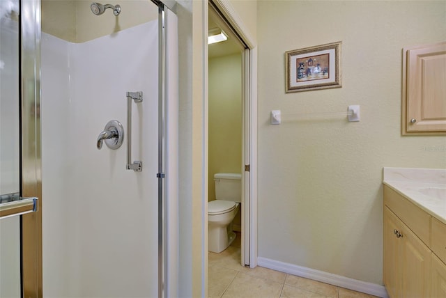 bathroom with vanity, a shower with shower door, tile patterned floors, and toilet