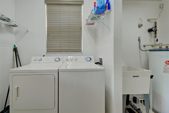 washroom featuring washing machine and clothes dryer, sink, and gas water heater