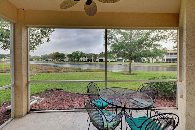 sunroom / solarium with a water view and ceiling fan