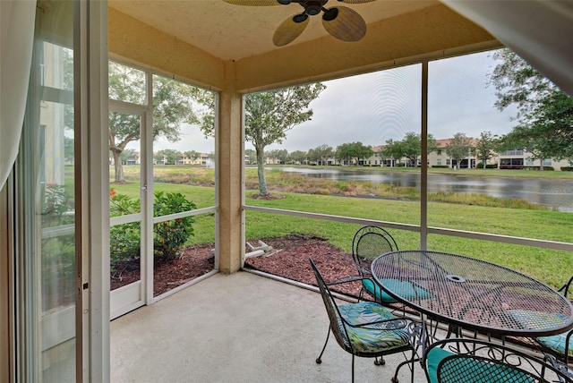 sunroom / solarium featuring a water view, ceiling fan, and vaulted ceiling