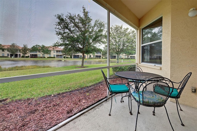 sunroom featuring a water view