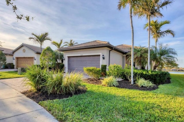 view of front of home with a garage and a front lawn