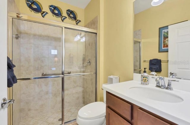 bathroom with walk in shower, vanity, and toilet