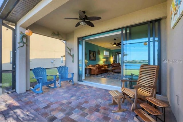 view of patio / terrace featuring a water view and ceiling fan