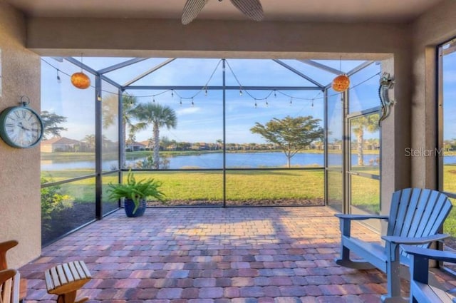 unfurnished sunroom with a water view and ceiling fan