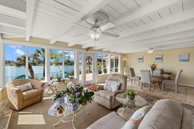 sunroom featuring beam ceiling, ceiling fan, and a water view