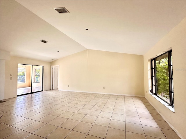 empty room with lofted ceiling and light tile patterned floors