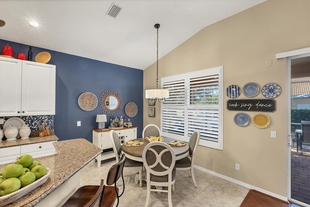 tiled dining space with lofted ceiling