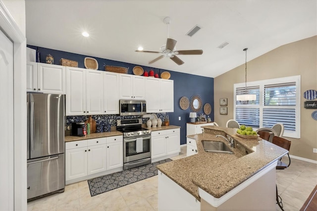 kitchen featuring decorative light fixtures, white cabinetry, sink, a kitchen island with sink, and stainless steel appliances