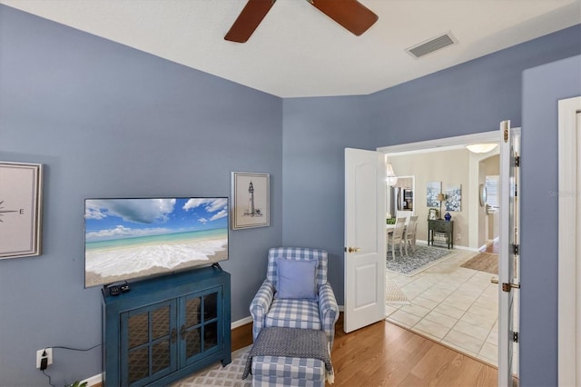 sitting room with hardwood / wood-style flooring and ceiling fan