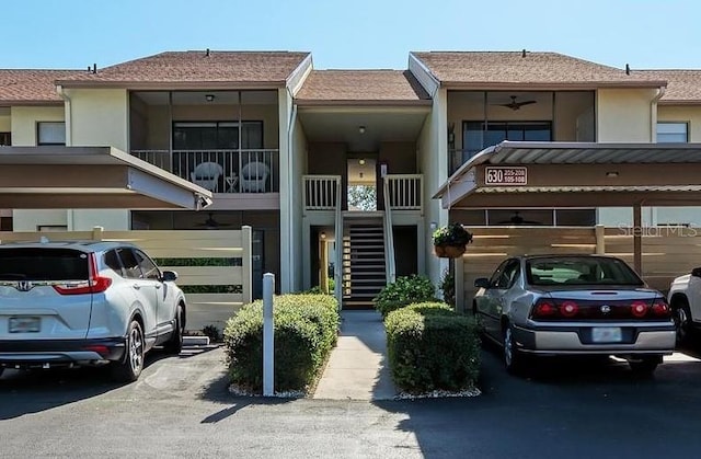 view of front of property with stairway, stucco siding, and covered parking