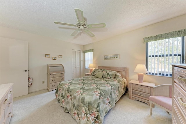 630 Bird Bay Dr E Unit 208, Venice, FL 34285 - bedroom featuring light carpet, a closet, a textured ceiling, and ceiling fan