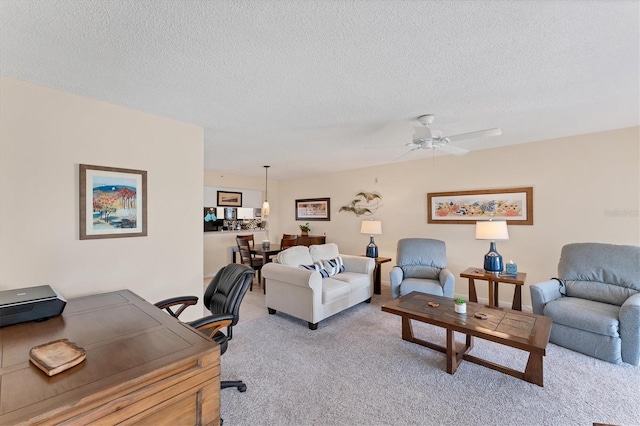 living room featuring light carpet, a textured ceiling, and ceiling fan