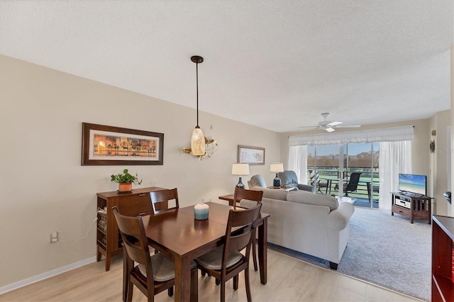 dining room with a textured ceiling, ceiling fan, and light hardwood / wood-style flooring