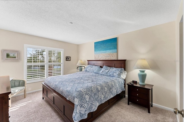 bedroom featuring light colored carpet and a textured ceiling