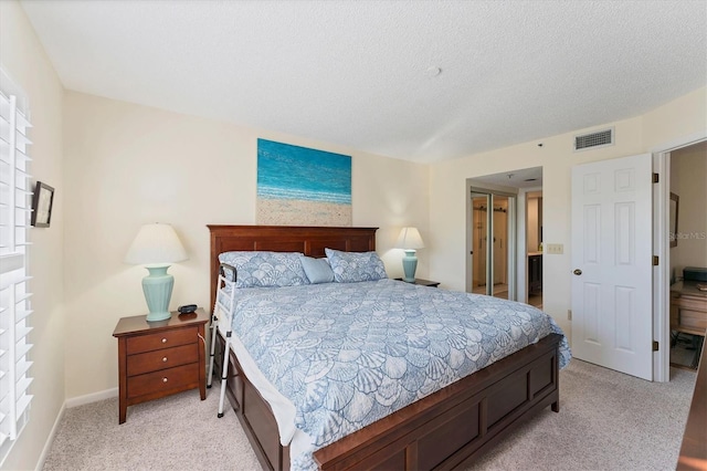 bedroom featuring light carpet and a textured ceiling