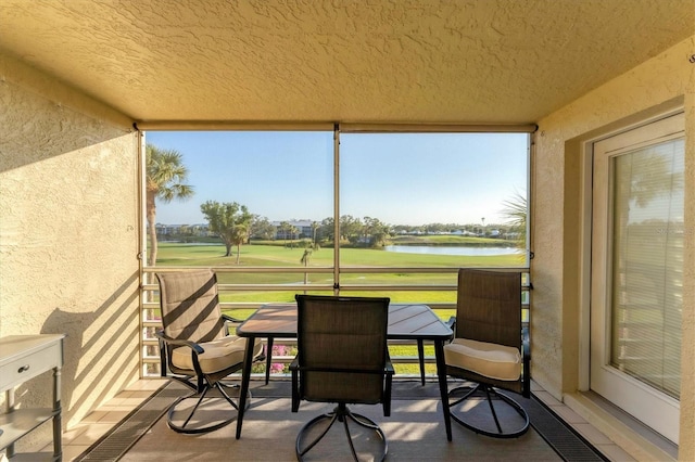 sunroom / solarium featuring a water view