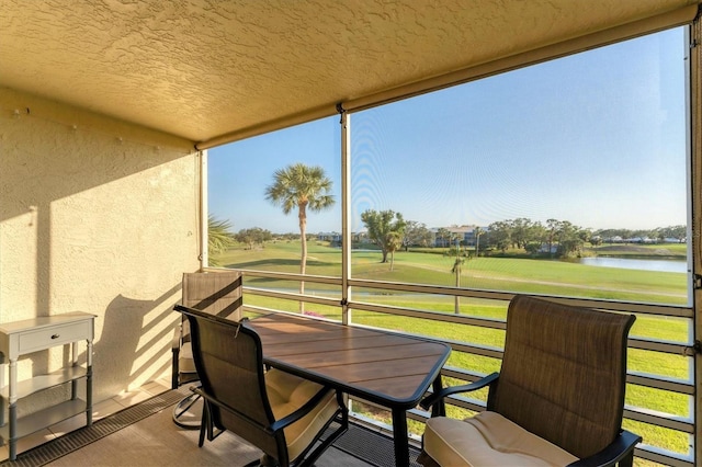 sunroom featuring a water view