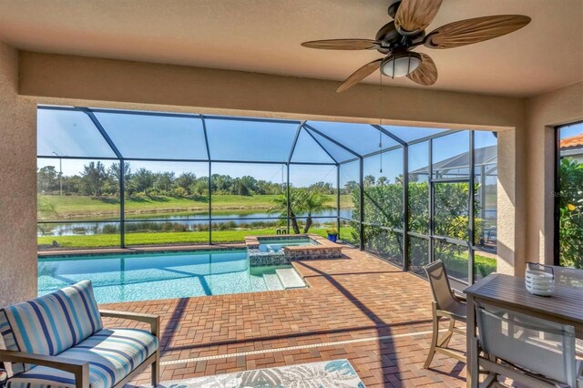 view of pool with an in ground hot tub, a water view, a patio area, and a lanai