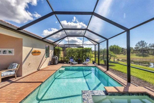 view of pool featuring a patio, a water view, and glass enclosure