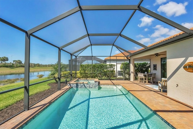 view of pool with a patio, an in ground hot tub, ceiling fan, glass enclosure, and a water view