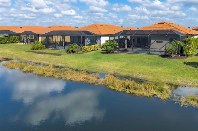 back of property featuring a water view, a lanai, and a yard