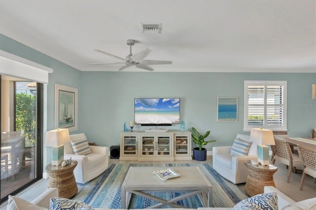 living room featuring ceiling fan and ornamental molding