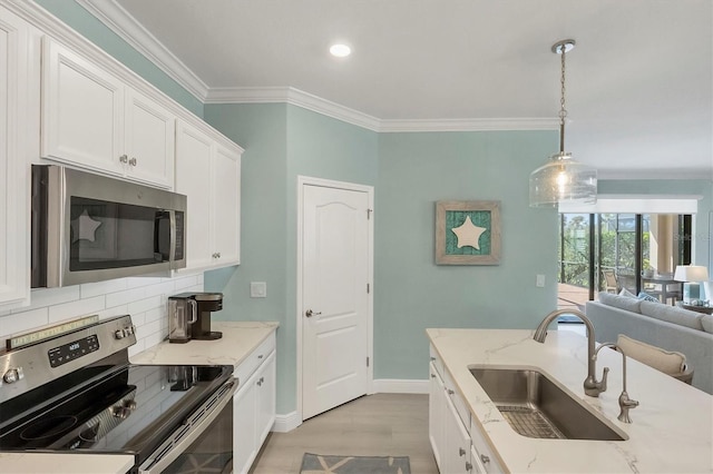 kitchen with white cabinetry, sink, hanging light fixtures, light stone counters, and stainless steel appliances