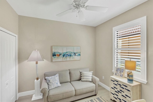 living room with light hardwood / wood-style flooring and ceiling fan