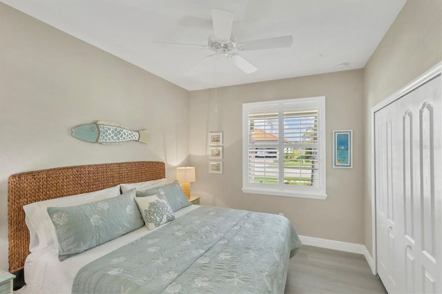 bedroom featuring ceiling fan, light hardwood / wood-style floors, and a closet