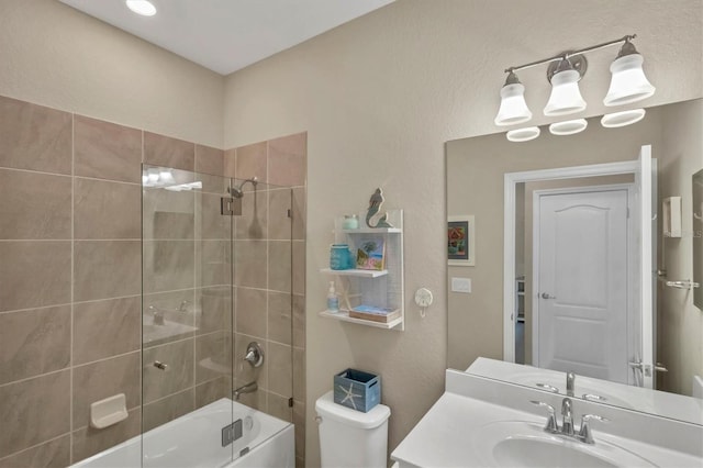 full bathroom featuring vanity, bath / shower combo with glass door, and toilet