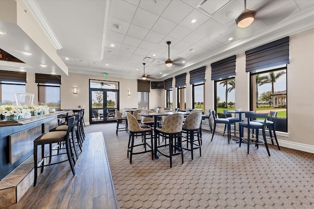 dining space with a tray ceiling, crown molding, ceiling fan, and a drop ceiling